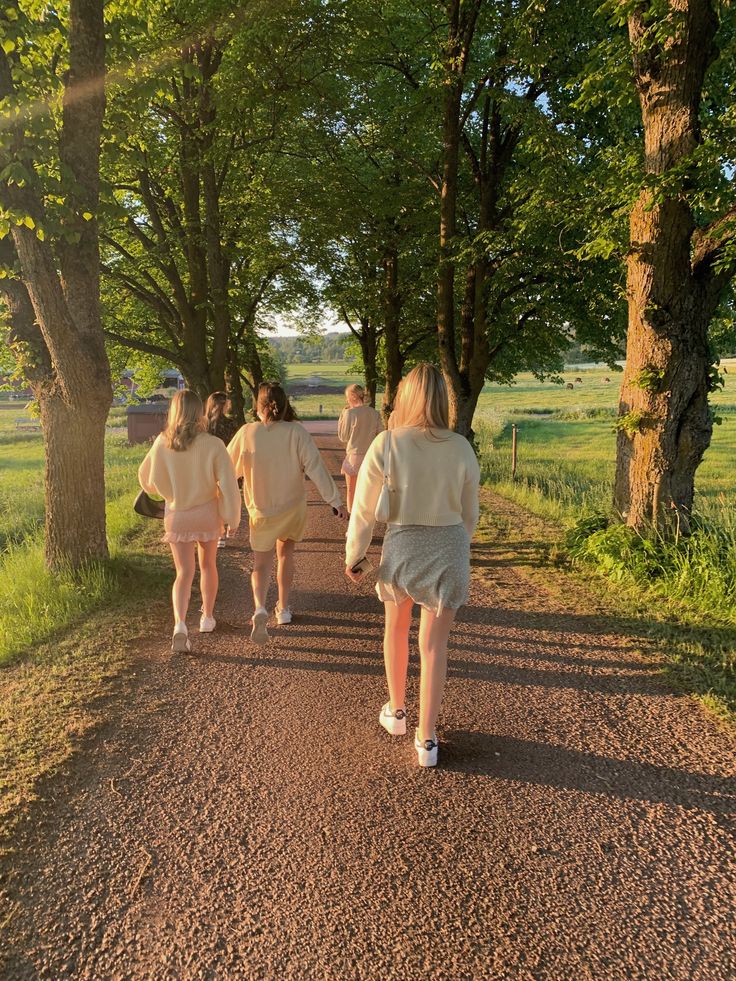 A small group of people walking together along a tree-lined path at early morning in Stockholm